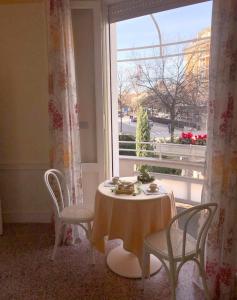tavolo e sedie in una stanza con finestra di B&B Romeo a SantʼArcangelo di Romagna