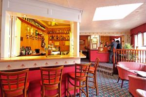 a bar in a restaurant with chairs and a counter at The Columbia Hotel in Wellingborough