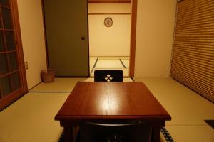 una sala de conferencias con una mesa de madera y una silla en Lumiere De Bonnart, en Okayama