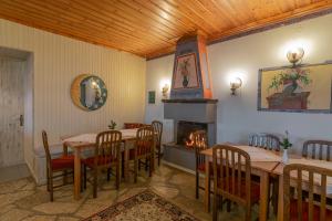 a dining room with tables and chairs and a fireplace at Guesthouse Selini in Vitsa