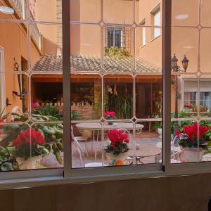 una finestra con vista su un cortile con piante in vaso di Hotel La Posada a La Palma