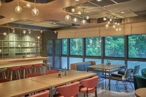 a restaurant with tables and chairs and windows at CityNote Hotel Shangxiajiu Pedestrian Guangzhou in Guangzhou