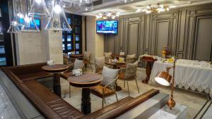 Un restaurante con mesas y sillas y un televisor. en Maroon Tomtom, en Estambul