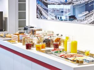 a buffet line with food and drinks on it at Hôtel Gustave Colmar in Colmar