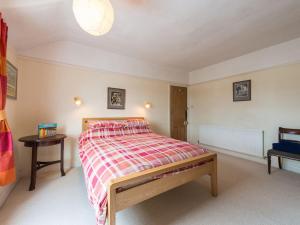 a bedroom with a bed with a red and white blanket at Glan Y Mor, 147 Station Road in Deganwy