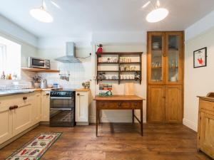 a kitchen with a wooden table and a stove at Glan Y Mor, 147 Station Road in Deganwy