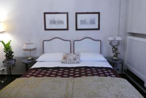 1 dormitorio con 1 cama con 2 cuadros en la pared en Bed and Breakfast Flowers en Génova