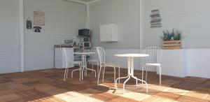 eine Küche mit weißen Tischen und Stühlen im Zimmer in der Unterkunft El Rincón de Isabel in Conil de la Frontera