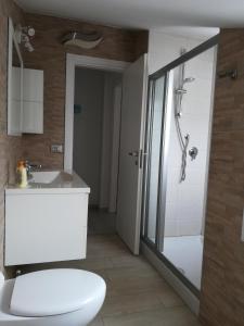 uma casa de banho com um WC, um chuveiro e um lavatório. em Condominio International em Lido di Jesolo