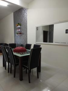 a dining room with a table with chairs and a mirror at Zah’ra Homestay in Kuala Lipis