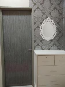 een badkamer met een spiegel naast een deur bij Zah’ra Homestay in Kuala Lipis