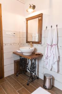een badkamer met een wastafel en een spiegel bij Zsindelyes Cottage in Érpatak