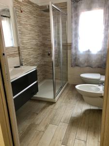 uma casa de banho com um chuveiro, um WC e um lavatório. em Casa Sophy em Chioggia