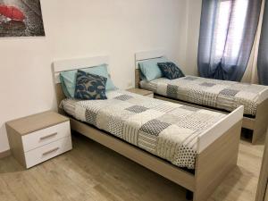 um quarto com duas camas e uma mesa de cabeceira em Casa Sophy em Chioggia