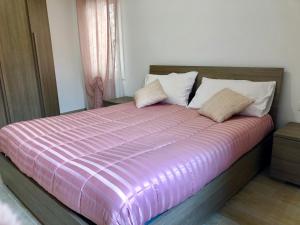 um quarto com uma cama grande e um edredão rosa em Casa Sophy em Chioggia