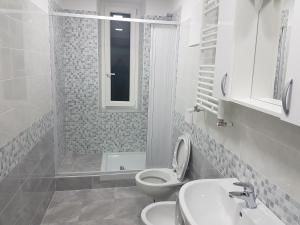 Baño blanco con aseo y lavamanos en Serafino Liguria Hotel, en Génova
