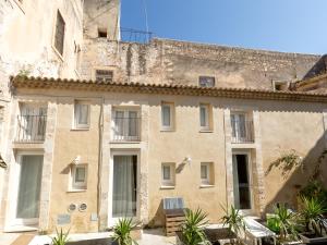 an old stone building with windows and plants at Residence Ortigia in Siracusa