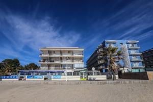 un edificio junto a una playa con una palmera en DIFFERENTFLATS Costa d' Or II, en Cambrils