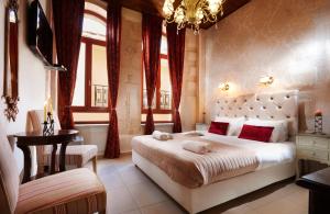 a bedroom with a large white bed with red pillows at Archontiko Old Town Suites in Rethymno Town