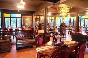 a dining room with tables and chairs and a chandelier at Rueanrubkwan in Ang Thong
