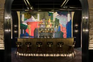 a bar with stools in front of a colorful wall at Chapter Roma in Rome