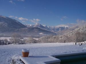 a cup of coffee sitting on a table in the snow at LE NID DOUILLET in Ore