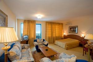 a hotel room with a bedroom and a bed at Hotel Iceberg in Balchik +83 photos