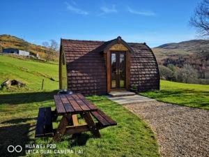 a small cabin with a picnic table in front of it at Bwlcheinion Sea View Glamping in Machynlleth