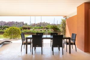 een eettafel en stoelen op een patio bij Sotogrande Marina 2 Bedroom Luxury Ground Floor Apt in Torreguadiaro