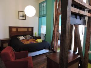 1 dormitorio con 1 cama y 1 silla en Hostal Casa Verde Limón en Valparaíso