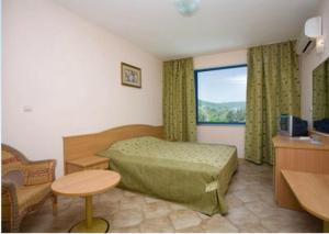 a hotel room with a bed and a window at Hotel Iceberg in Balchik