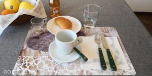a table with a plate with a cup and a plate of bread at Casa della Sala Spada in Casale Monferrato