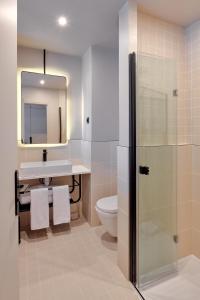 a bathroom with a sink and a toilet and a mirror at Tinah Paris, Réaumur - Montorgeuil in Paris