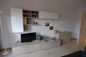 a living room with a flat screen tv on a cabinet at Biroldi Apartment in Varese