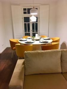 a dining room with a table and yellow chairs at Casas Rosa Sousa in Felgueiras