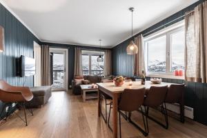 Skarsnuten Apartments في هيمسيدال: مطبخ وغرفة معيشة مع طاولة وكراسي