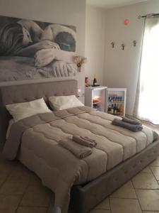 um quarto com uma cama grande e uma fotografia na parede em Suite Margarita em Mazara del Vallo