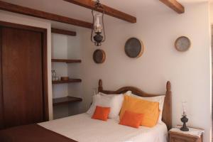 1 dormitorio con 1 cama con almohadas de color naranja en Retiro Da Avo Lídia - Turismo Rural, en Mendiga