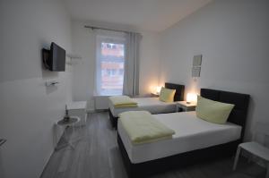a small room with two beds and a tv at Apartment Dusseldorf-City in Düsseldorf
