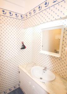 La salle de bains est pourvue d'un lavabo et d'un miroir. dans l'établissement T2 Holiday Cottage near the beach | B112, à Lagoa