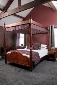 1 dormitorio con cama de madera y dosel en The Peacock, en Bakewell