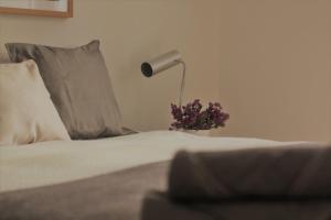 un lit avec une lampe et un vase avec des fleurs. dans l'établissement Baixa-Chiado Cosy 5 bedrooms, à Lisbonne