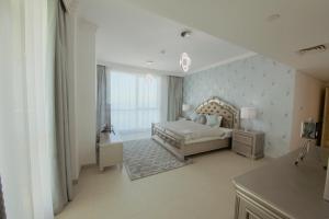 a bedroom with a bed and a dresser and a window at Stunning 5* 4BR-Oceanfront-Apartment in Dubai