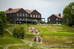 a building on top of a hill with a water fountain at National Golf Resort in Klaipėda