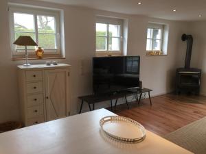 a living room with a television and a table at Hof Busen Farm Haus in Mönchengladbach