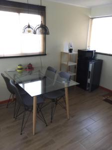 uma sala de jantar com mesa e cadeiras de vidro em Los Pinos de Quilvo em Romeral mais 15 fotografias