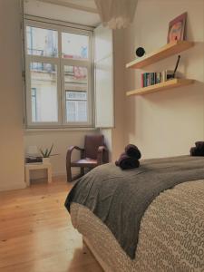 - une chambre avec un lit, une fenêtre et une chaise dans l'établissement Baixa-Chiado Cosy 5 bedrooms, à Lisbonne