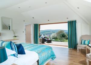 a bedroom with a bed and a large window at The Horn Of Plenty in Tavistock