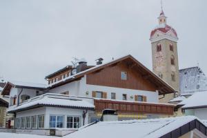 una città con torre dell'orologio e un edificio di Gasthof Paul a Naz-Sciaves