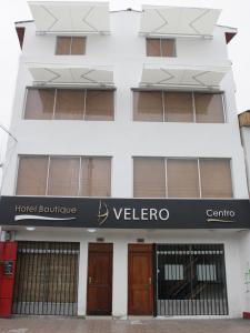 a building with a welcome sign in front of it at Hotel Velero Centro in Iquique